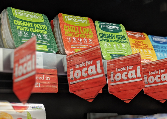Local cheeses merchandised on a shelf.