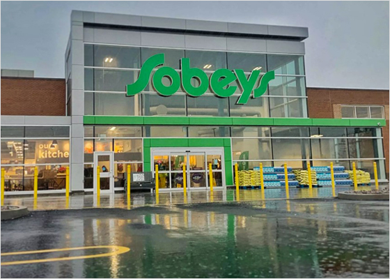 Une photo de la façade de Sobeys et du stationnement fait de sacs en plastique recyclé.